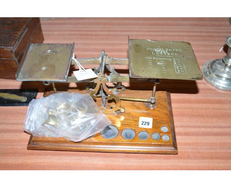 A set of brass postal scales on oak base.