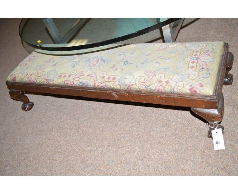 A long rectangular stool with drop in tapestry seat raised on claw and ball feet.