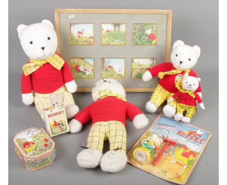 A quantity of Rupert Bear collectables. Includes teddy bears, boxed toy, tin, print, etc.  