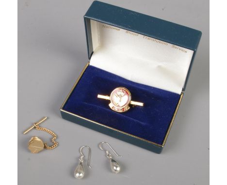 A small quantity of jewellery. Includes 9ct gold tie pin, pair of silver earrings and a silver gilt and enamel badge.  