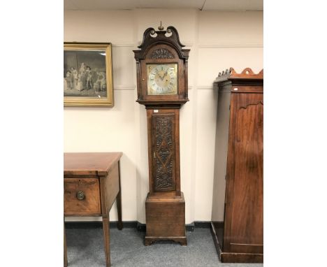 A carved oak cased eight day longcase clock with brass and silvered dial and pendulum, height 214 cm.