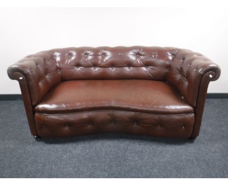 An early 20th century shaped brown button leather settee 