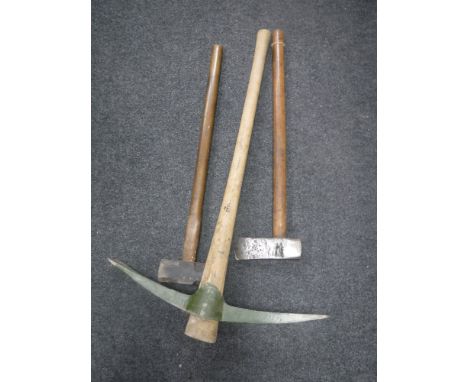 A pick axe together with an axe and sledge hammer 