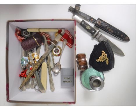 A box containing steward's badges, Zippo lighter, butter knives, letter opener, knife in leather sheath etc