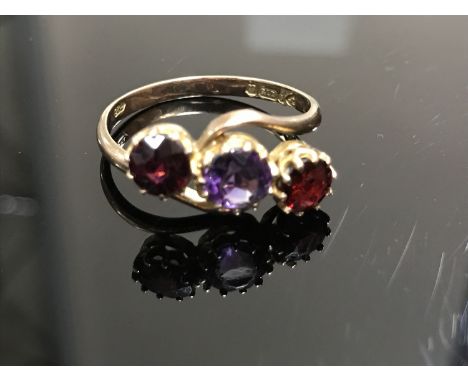 A 9ct gold amethyst and garnet three stone crossover ring, size S