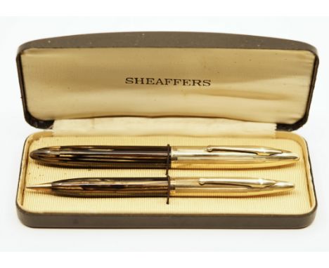 Sheaffer Crest gold filled caps with gold/black stripe barrels. Piston fill, in original box with fine nib. Overall good cond