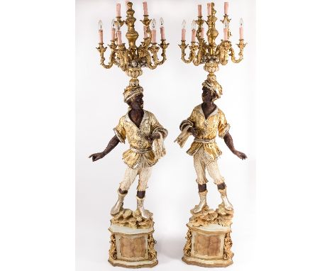 A pair of floor standing blackamoors, each figure in traditional dress with nine-light chandelier above their heads, 209cm hi