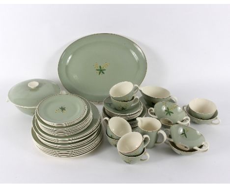 A Poole pottery part dinner service, of fifty-three pieces, decorated berries and leaves on an olive green ground