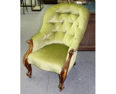 A Victorian button back armchair on carved front legs