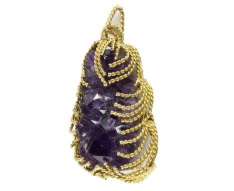 A 1970s amethyst specimen pendant in a cage setting of twisted 9ct gold, 7cm long including bail