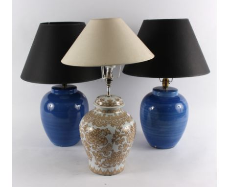 Two blue pottery lamp bases, 28cm high and another with cream and gold pottery base, 30cm high