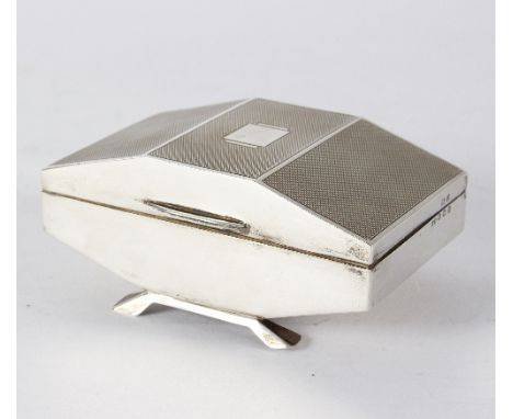 An Art Deco silver jewellery casket, Birmingham 1938, of carved rectangular form, with engine-turned decoration, raised on fo