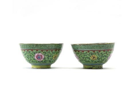 A pair of early 19th Century Cantonese enamel tea bowls, finely enamelled flowerheads and scrolls on a green ground within a 