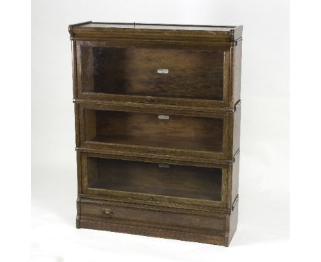 An oak Globe Wernicke bookcase of three glazed stacking shelves above a single drawer, 87cm wide