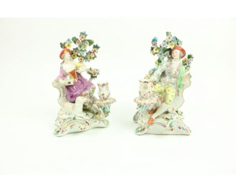 A pair of Derby style porcelain&nbsp;Candlestick Groups, one modelled as an elegant gentleman with bird on his knee, seated b