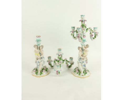 A pair of Sitzendorf porcelain three branch four light flower encrusted Candelabra, c. 1900, each stem modelled with classica