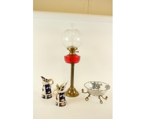 A brass Oil Lamp, with ruby glass reservoir and bulbous glass shade, 69cms (27"), a pair of English porcelain Jugs with drago