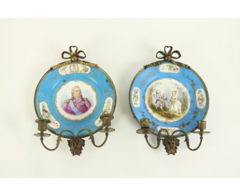 A pair of very attractive Sevres style brass mounted porcelain Candle Sconces, each crested with a brass ribbon bow, above a 