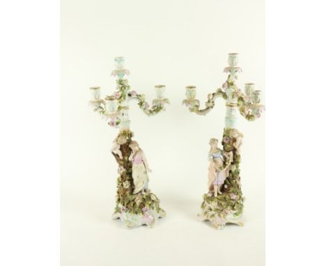 A good pair of Sitzendorf flower encrusted Candelabra, c. 1900, each with three arms and a centre light, the stem flanked wit