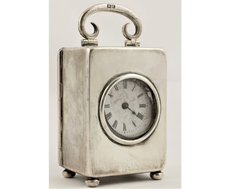 A miniature silver Carriage Clock, London 1912, with swing handle, lever movement and enamel dial with Roman numerals, 9cms (