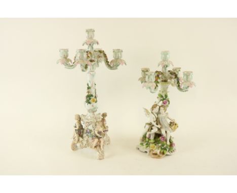 Two similar German porcelain flower encrusted four branch - five light Candelabras, one with cupid and girl, the other with t