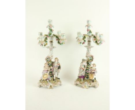 A pair of Sitzendorf porcelain flower encrusted four branch five-light Candelabra, each with an asymmetrical stem flanked wit