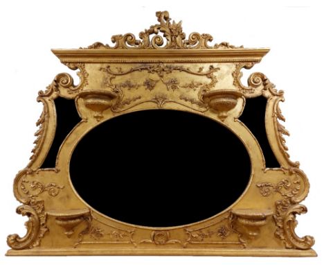 An ornate gilt and gesso Overmantel, with leaf scroll and floral crest above a large oval bevelled plate and two mirror spand