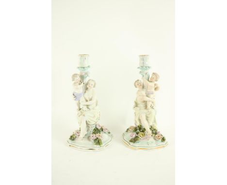 A pair of Dresden porcelain Candlestick Groups, each with classical woman and child forming the stem, on a flower encrusted s
