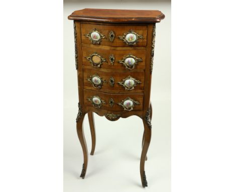 A French serpentine shaped brass mounted petite Commode, 20th Century, with oval porcelain panels, depicting figures in lands