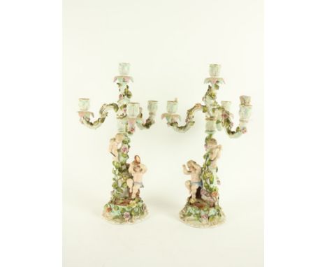 A pair of Sitzendorf flower encrusted three branch four light Candelabra, each modelled with musical cherubs, on an ornate ba