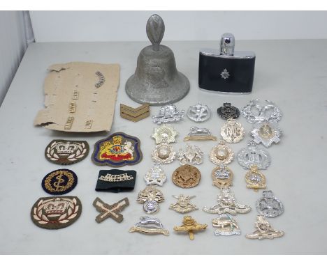 A box of anodized Military Badges and Buttons, a Hip Flask and a commemorative aluminium Hand Bell