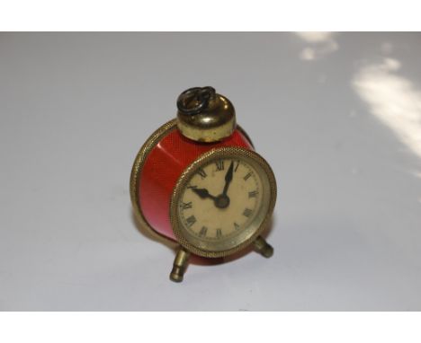 A vintage tape measure in the form of an enamel decorated alarm clock 
