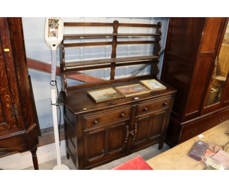 A dark Ercol dresser fitted two drawers raised on cupboard base