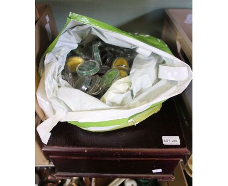 An old wooden box filled with vintage watch glasses, and a bag of coin cases, with felt liners