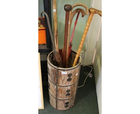 A circular wooden and brass bound vintage stick stand with contents