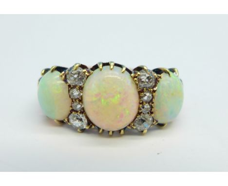 An 18ct gold, eight stone diamond and three stone opal ring, 4.2g, N