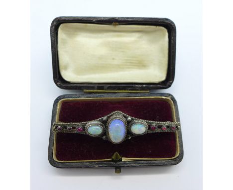 An opal and red stone set brooch, 57mm