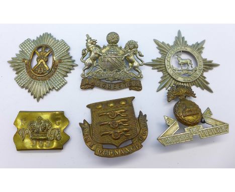 Three cap badges, The Lancashire Fusiliers, Manchester and Army Ordnance Corps, two other badges lacking loops The Royal Scot