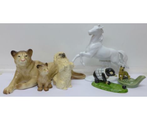 A Melba Ware lioness and lion cub, a Royal Doulton Pekinese, a German model of a white horse, a Wade pipe stand and a model o