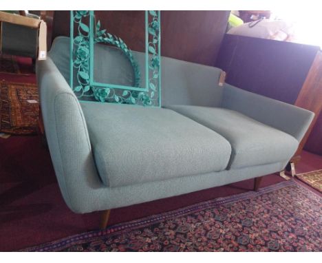 A contemporary two seater sofa with turquoise upholstery, raised on tapering walnut supports, H.70cm W.150cm D.80cm 