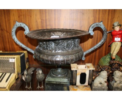 A LARGE VINTAGE TWIN HANDLED METAL URN WITH FLORAL DECORATION 