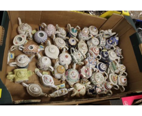 A QUANTITY OF MINIATURE CERAMIC TEAPOTS 