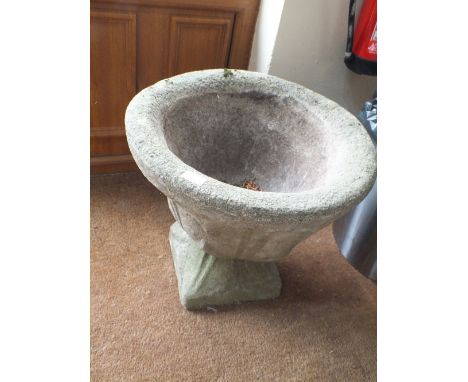 A LARGE STONE PLANTER ON BASE