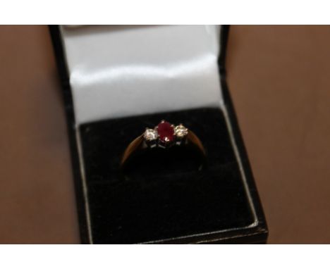 AN 18CT GOLD DRESS RING SET WITH A RUBY FLANKED BY DIAMONDS 