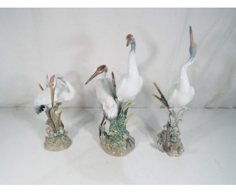 Lladro - Three figurines by Lladro depicting cranes to include 1612 'Preening Crane', 1614 'Dancing Crane' and 1611 'Courting
