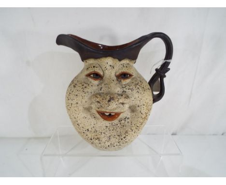 An Israeli ceramic jug decorated with grotesque face, approx 21cm (h)