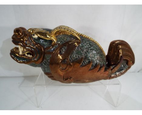 A large ceramic model depicting a dragon, approx 39cm (l) signed to the base 