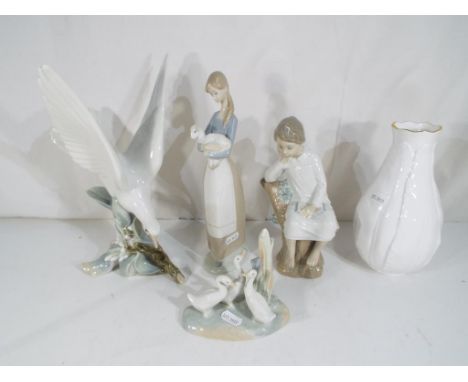 Three Lladro figurines to include 4550 'Turtle Dove', 4505 'Girl With Lamb' and a seated boy, largest model being approximate