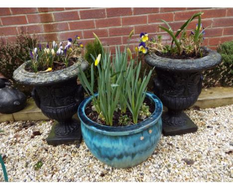 Two stone urns and a planter with shrubs and plants included in the lot