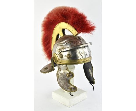 A reproduction Roman Centurion helmet constructed from sheet steel and brass with a red plume and a reproduction Greek Corint